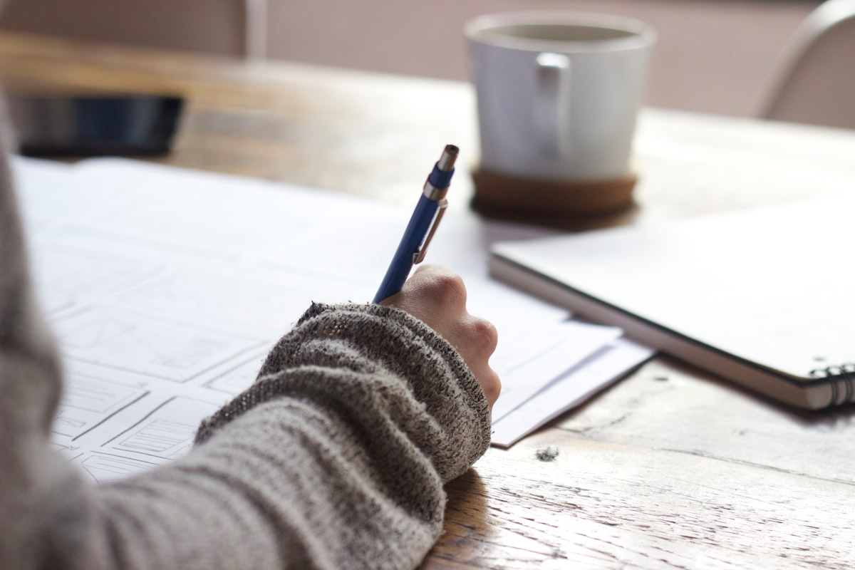 Student writing a CLB language test for Canada immigration at a classroom desk