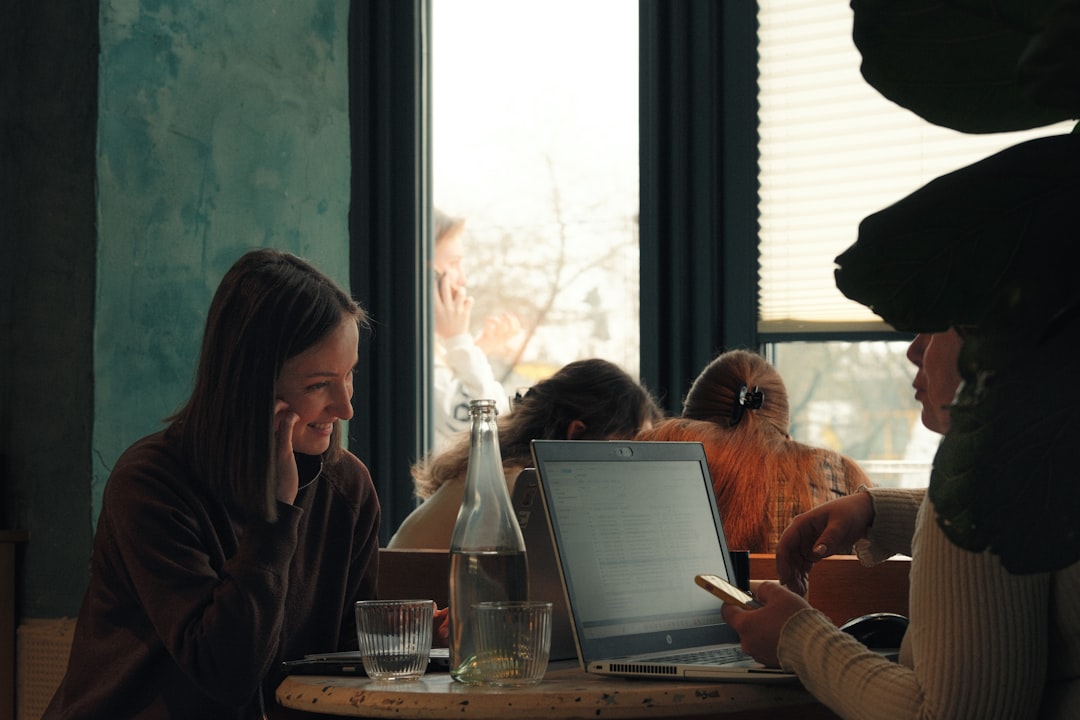International students collaborating on co-op project with laptops at a workspace in Canada