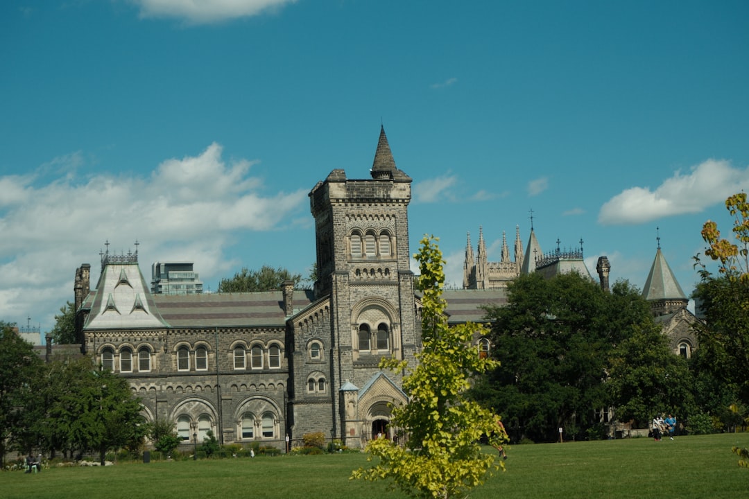 Historic gothic university building with green lawn on a Canadian campus