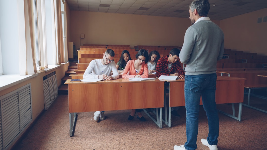Adult students writing an IELTS preparation test at desks in a Canadian language school classroom