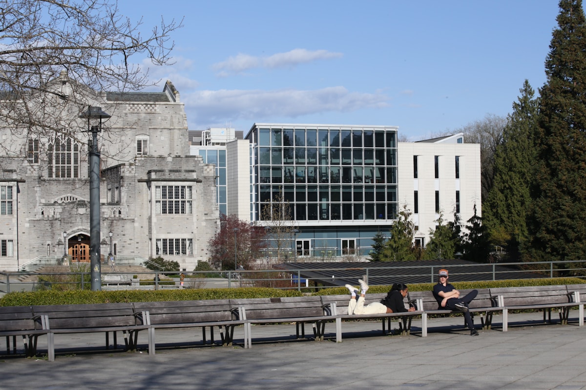Students relaxing on benches outside a Canadian university building on campus