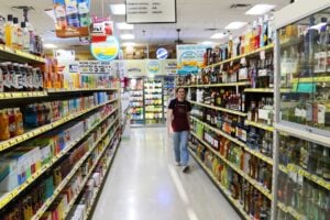 Student walking down a brightly lit grocery store aisle in Canada comparing prices