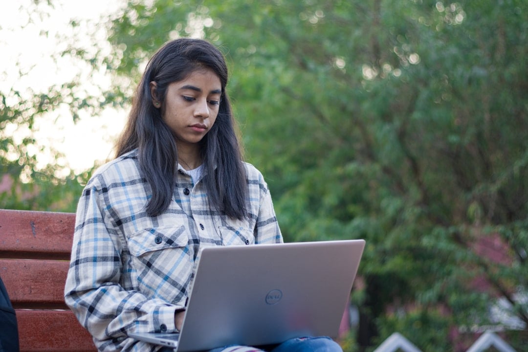 Indian international student studying outdoors on a Canadian university campus