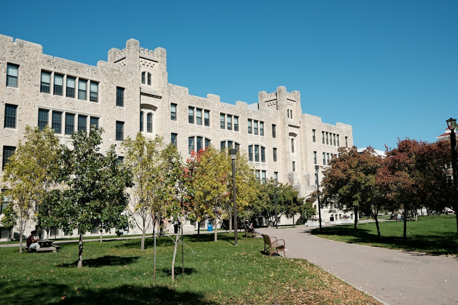 Large limestone academic building and walkway at a Canadian Prairie university in autumn
